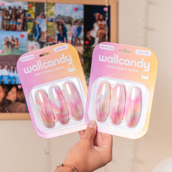Two packages of wallcandy wall stickers held by a hand with a blurred background