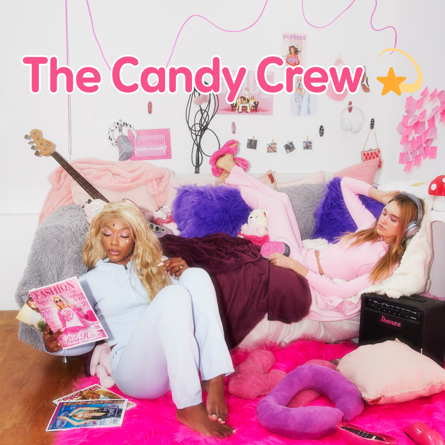 Two women relaxing in a colorful dorm-style room with WallCandy hooks on the wall and text overlay “The Candy Crew.