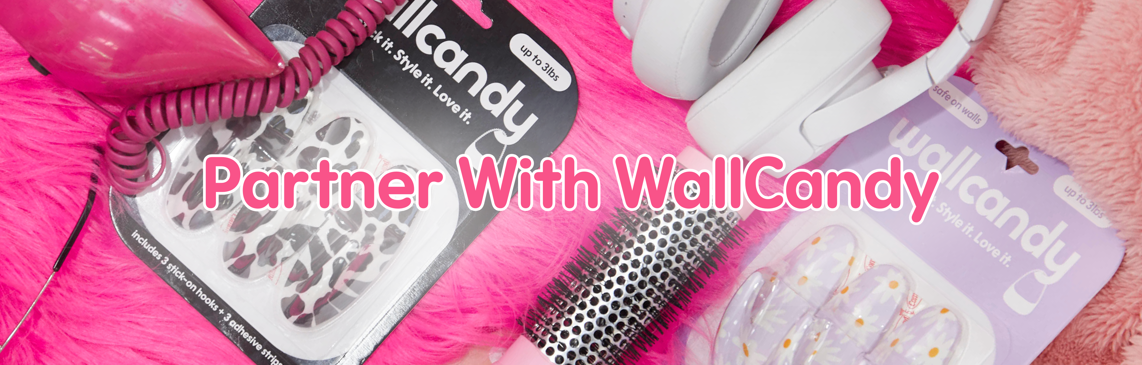 WallCandy adhesive hook packages displayed with lifestyle items on a pink background and text overlay “Partner With WallCandy.